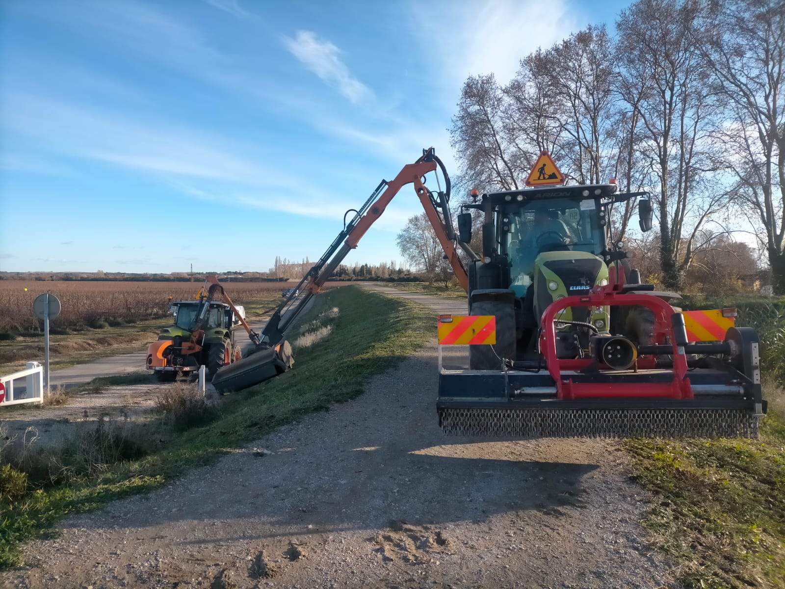 Deux tracteurs Claas avec bras faucheur entretenant les accotements routiers